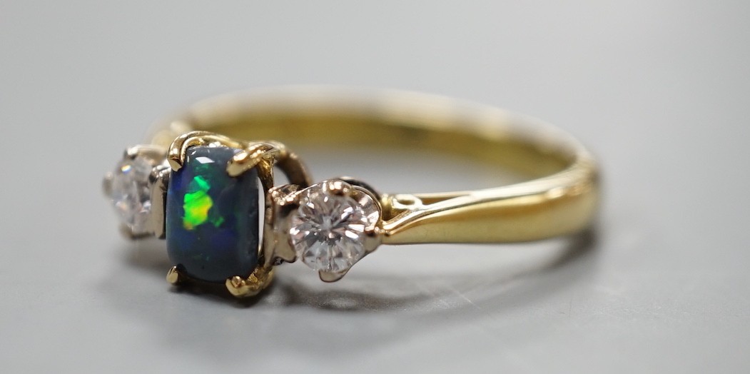 A modern 18ct gold, black opal and diamond set three stone ring, size Q, gross weight 4.6 grams